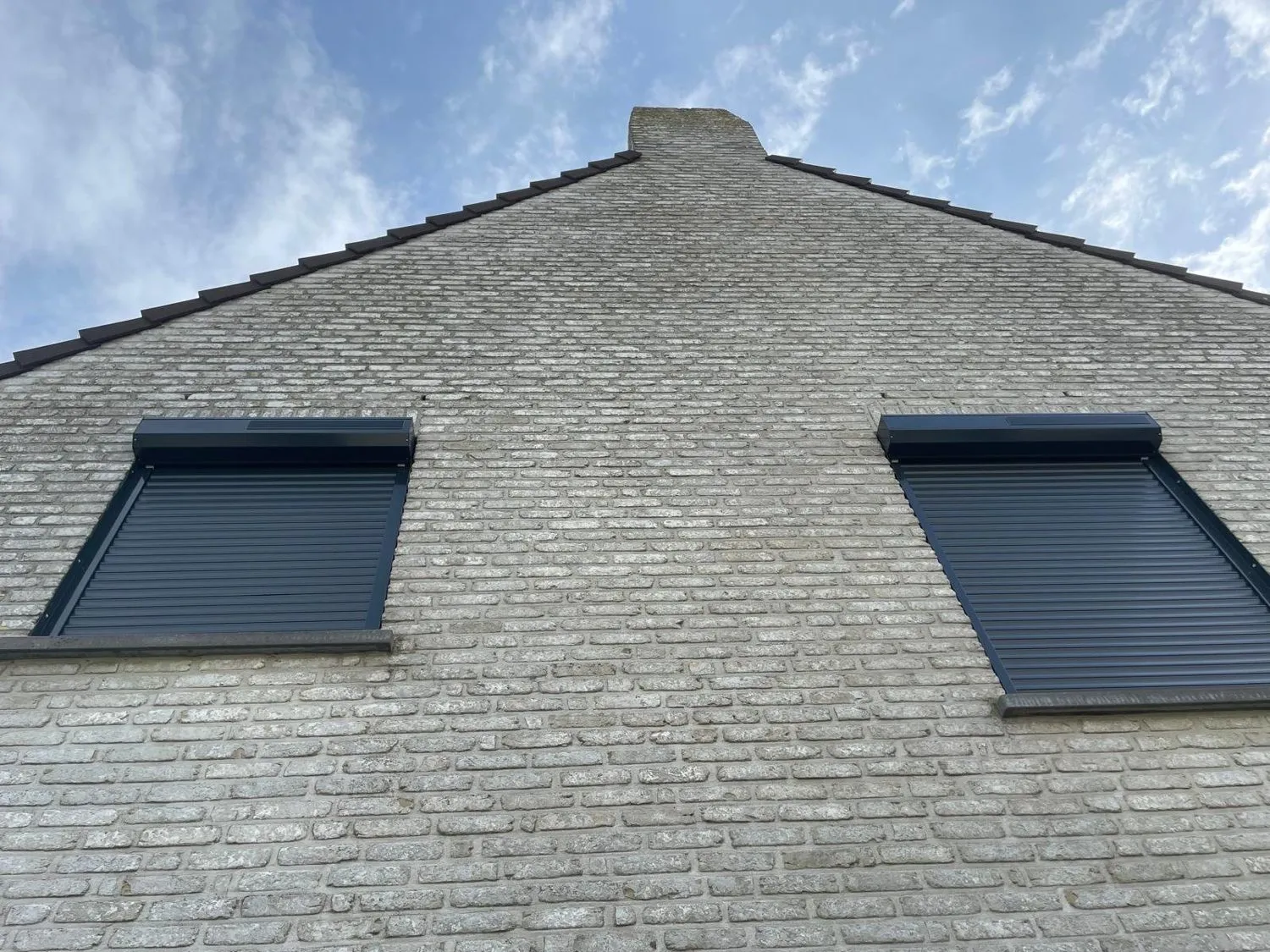 Rolluiken die Atelio plaatste aan een bakstenen gevel.