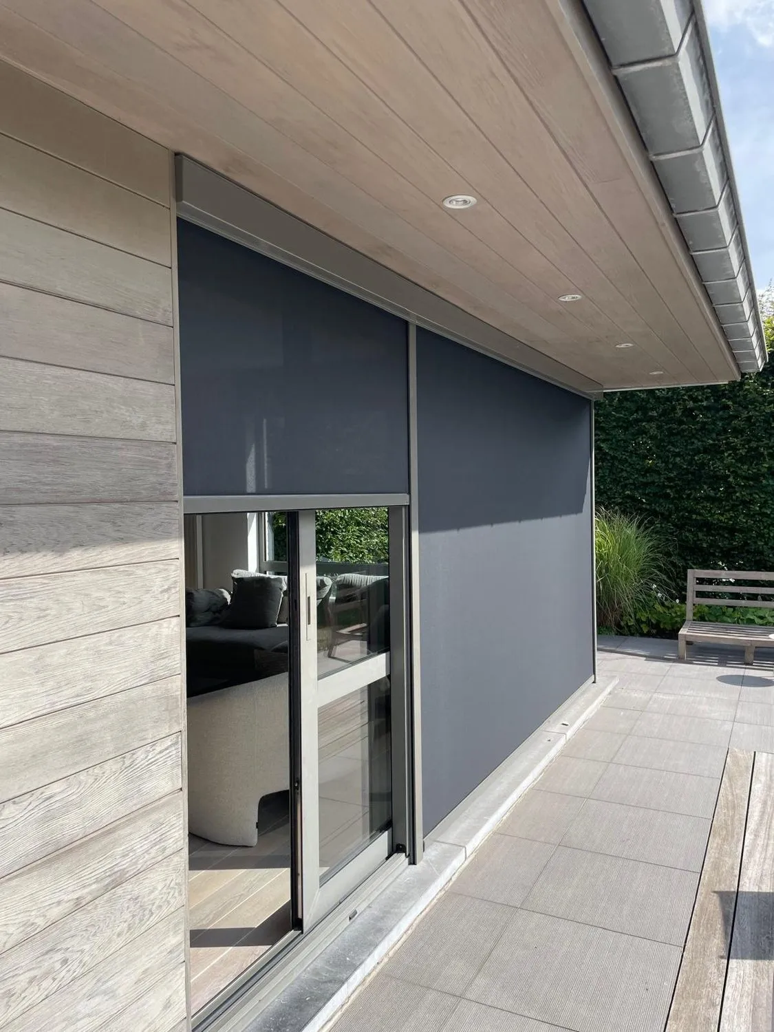 Screens die Atelio plaatste aan een woning met een houten gevel.