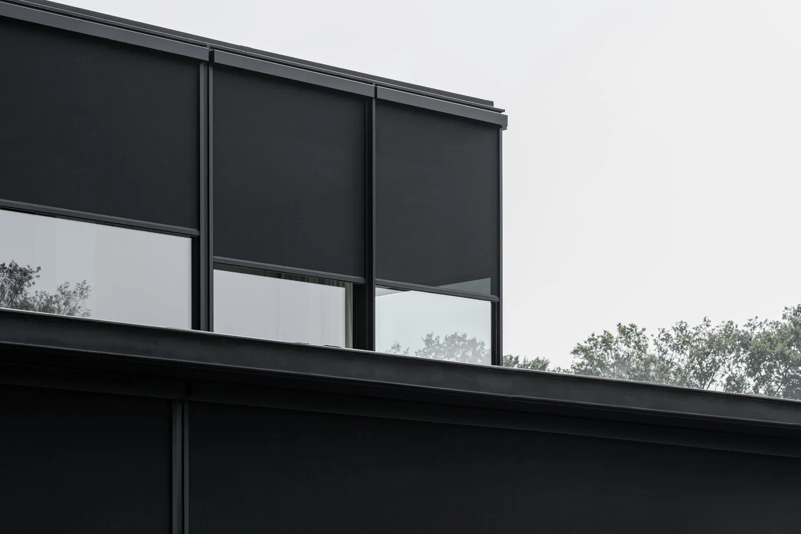 Drie screens met neergelaten doek op een moderne woning